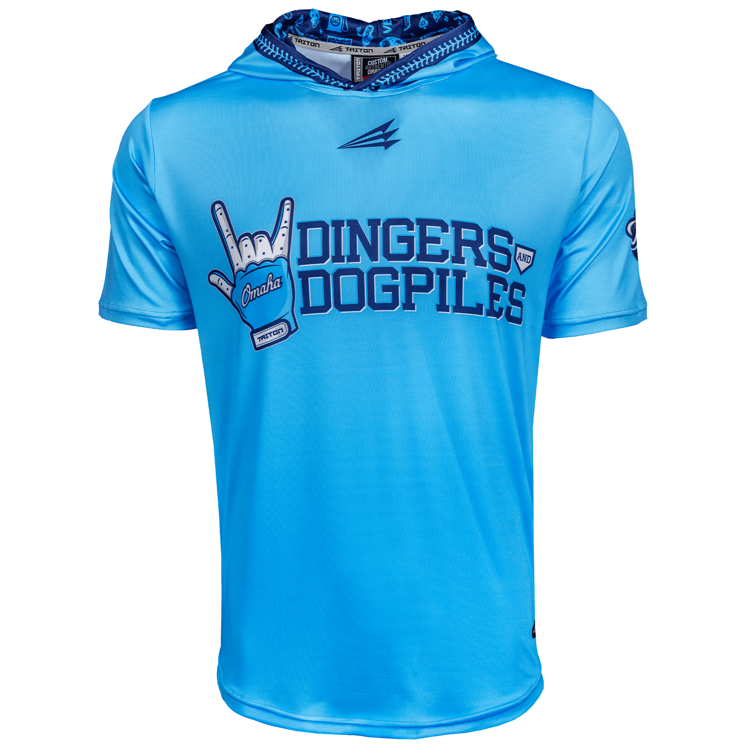 A light blue short-sleeve athletic pullover with a hood, featuring the text 'DINGERS AND DOGPILES' in dark blue across the chest and a baseball batting glove graphic on the left side that says 'Omaha'. The pullover has a patterned blue and black hood lining and a stylized logo on the chest.